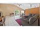 Spacious living room featuring tile flooring, a vaulted ceiling with ceiling fan and sliding glass doors to the lanai at 1803 Tillstream Dr, Orlando, FL 32818