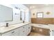 Bathroom with a double sink vanity, tile accents, and a soaking tub with jacuzzi jets at 1824 Dorris Dr, Orlando, FL 32807