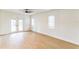 Bright bedroom with wood-look floors, a ceiling fan, and double doors leading to the backyard at 1824 Dorris Dr, Orlando, FL 32807