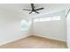 This bright bedroom features hardwood floors, a ceiling fan, and a wall of windows at 1824 Dorris Dr, Orlando, FL 32807