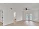 Bright bedroom featuring wood-look floors, a ceiling fan, and double doors leading to the backyard at 1824 Dorris Dr, Orlando, FL 32807