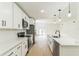 Open kitchen features a large island, modern appliances, white cabinets, sleek countertops, and hardwood flooring at 1824 Dorris Dr, Orlando, FL 32807