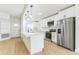 Modern kitchen with an island, pendant lights, stainless steel appliances, white cabinetry, and hardwood floors at 1824 Dorris Dr, Orlando, FL 32807