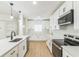 Modern kitchen features sleek appliances, white cabinets, granite countertop, stylish black faucet and wood-look flooring at 1824 Dorris Dr, Orlando, FL 32807