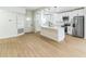 Bright open kitchen features white cabinets, stainless steel appliances, quartz countertops, and hardwood floors at 1824 Dorris Dr, Orlando, FL 32807