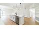 Open kitchen with white cabinetry, stainless appliances, and hardwood flooring seamlessly connects with the entryway at 1824 Dorris Dr, Orlando, FL 32807