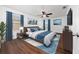 Main bedroom with dark wood floors, blue accents, ceiling fan, and natural light at 1951 Betsy Ross Ln, St Cloud, FL 34769