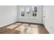Sunlit bedroom showcasing three large windows, light walls, and hardwood floors at 2018 Packing District Way, Orlando, FL 32804