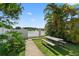 Backyard with a picnic table next to a lush garden overlooking a serene lake at 2076 Shannon Lakes Blvd, Kissimmee, FL 34743