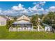Back view of the home featuring an enclosed patio, white picket fence, and lush green lawn at 2076 Shannon Lakes Blvd, Kissimmee, FL 34743