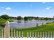 Scenic backyard view of a lake with a fountain, surrounded by lush greenery and houses in the distance at 2076 Shannon Lakes Blvd, Kissimmee, FL 34743
