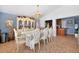 Formal dining area with vintage hutch, ornate chandelier, and wood-patterned tile at 2076 Shannon Lakes Blvd, Kissimmee, FL 34743