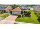 Well-maintained home with lush lawn, brick driveway, and attached two-car garage at 2076 Shannon Lakes Blvd, Kissimmee, FL 34743