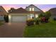 Charming single-Gathering home with a brick driveway and well-maintained landscaping at dusk at 2076 Shannon Lakes Blvd, Kissimmee, FL 34743