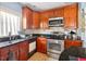 Functional kitchen design featuring wood cabinets, a stainless steel oven, and double sink at 2076 Shannon Lakes Blvd, Kissimmee, FL 34743