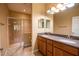 Bathroom featuring double vanity sinks, wood cabinets, walk-in shower, and a neutral color palette, offering both style and functionality at 2673 Rutledge Ct, Winter Haven, FL 33884