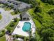 Community pool and patio space surrounded by green landscaping, townhouses and trees at 2673 Rutledge Ct, Winter Haven, FL 33884