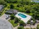Aerial view of the community pool with lounge chairs, landscaping, and a parking area at 2673 Rutledge Ct, Winter Haven, FL 33884