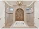 Elegant bathroom featuring a jacuzzi tub, chandelier, and decorative tile wall at 3130 Butler Bay N Dr, Windermere, FL 34786