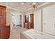 Bright bathroom with a large soaking tub, chandelier, and wood vanity at 3130 Butler Bay N Dr, Windermere, FL 34786