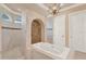 Elegant bathroom featuring a jacuzzi tub, chandelier, and decorative tile wall at 3130 Butler Bay N Dr, Windermere, FL 34786