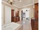 Bathroom featuring a large soaking tub, chandelier, wood vanity, and bedroom access at 3130 Butler Bay N Dr, Windermere, FL 34786