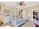 Bright bedroom with four-poster bed, chandelier and desk, with view into a kitchen at 3130 Butler Bay N Dr, Windermere, FL 34786