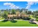 Beautiful home featuring a terracotta roof, arched windows, mature trees and lush landscaping at 3130 Butler Bay N Dr, Windermere, FL 34786