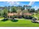 Beautiful home featuring a terracotta roof, arched windows, mature trees and lush landscaping at 3130 Butler Bay N Dr, Windermere, FL 34786