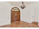 Elegant foyer featuring double doors, terra cotta floors, chandelier, and arched doorway at 3130 Butler Bay N Dr, Windermere, FL 34786