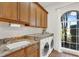 Well-lit laundry room with granite countertops, wood cabinets and a large window at 3130 Butler Bay N Dr, Windermere, FL 34786