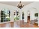 Sunlit living room featuring arched windows, terra cotta floors, chandelier, and arched doorway at 3130 Butler Bay N Dr, Windermere, FL 34786