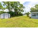 Property featuring a large grassy yard with a storage shed and mature trees at 3515 Leslie Dr, Orlando, FL 32806