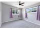 Bright bedroom with ceiling fan, neutral carpet and two windows adorned with purple curtains at 3515 Leslie Dr, Orlando, FL 32806