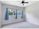Well-lit bedroom with a ceiling fan, plush gray carpet and two windows, offering ample natural light at 3515 Leslie Dr, Orlando, FL 32806