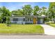 Charming single-story home with a well-manicured lawn, covered parking and a bright yellow front door at 3515 Leslie Dr, Orlando, FL 32806