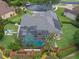 Gorgeous aerial view of the home showcasing the screened pool, solar panels, manicured landscaping, and community at 3619 King George Dr, Orlando, FL 32835