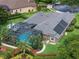 Aerial view of the home with a screened pool, solar panels, and lush landscaping at 3619 King George Dr, Orlando, FL 32835