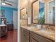 Bright bathroom features a double sink vanity with granite countertops and a view to the bedroom at 3619 King George Dr, Orlando, FL 32835
