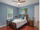 Comfortable bedroom with a window, ceiling fan, wood floors, blue accent wall and a cozy bed at 3619 King George Dr, Orlando, FL 32835
