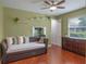 Well-lit bedroom with a comfortable daybed, wood floors, green walls, and ample closet space at 3619 King George Dr, Orlando, FL 32835