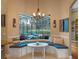 Inviting breakfast nook with a window view of the screened pool and backyard featuring blue cushions and a stylish chandelier at 3619 King George Dr, Orlando, FL 32835
