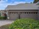 Attached two-car garage with decorative doors and well-maintained landscaping at 3619 King George Dr, Orlando, FL 32835