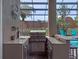 This outdoor kitchen features stainless appliances, granite countertops, and bar seating in the screened pool area at 3619 King George Dr, Orlando, FL 32835