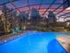 Inviting screened pool with cool-blue Adirondack chairs, lounge seating and mature tropical landscaping at 3619 King George Dr, Orlando, FL 32835
