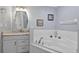 Bright bathroom showcasing a large soaking tub with a white tile surround and single sink vanity at 401 Gannet Ct, Kissimmee, FL 34759