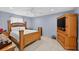 Bedroom with a wooden bed frame, wood furniture, and tile floors throughout at 401 Gannet Ct, Kissimmee, FL 34759
