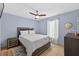 Comfortable bedroom featuring light blue walls, ceiling fan, and a window for natural light at 401 Gannet Ct, Kissimmee, FL 34759