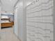 Hallway view of main bedroom showcasing tiled floors, ceiling fan, and light blue walls at 401 Gannet Ct, Kissimmee, FL 34759