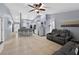 Open-concept living area with a tile floor, a ceiling fan, and access to the dining room at 401 Gannet Ct, Kissimmee, FL 34759